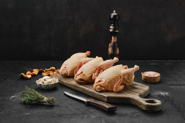 Trois petit poulet cru sur une planche à découper en bois