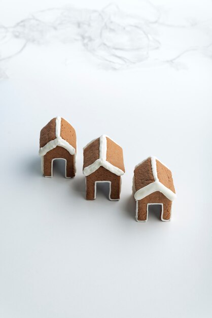 Trois petites maisons en pain d'épice sur fond blanc. Produits de boulangerie de Noël.