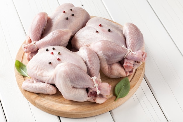 Trois Petits Poulets Crus Sur Une Planche à Découper