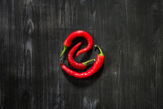 Trois piments sur une surface noire