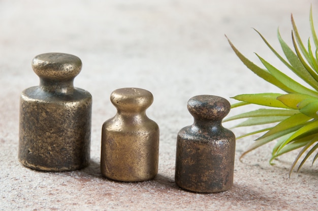 Trois poids en bronze antique pour balances sur béton.