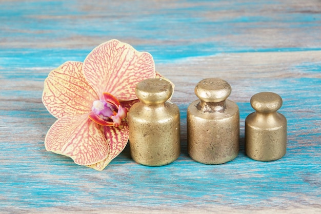 Trois poids en bronze antique pour balances sur fond de bois bleu. Copiez l'espace pour les accessoires de photographie de texte et de nourriture.