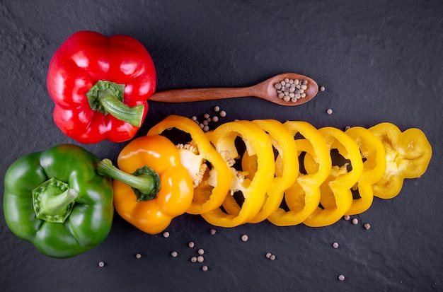 Trois poivrons doux sur un fond en bois, salade de légumes de cuisson