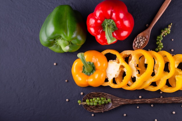 Trois poivrons doux sur une table en bois, salade de légumes de cuisson