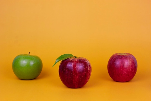 Trois pommes différentes fruits verts et rouges isolés sur fond jaune Annonces de concept de fruits sains