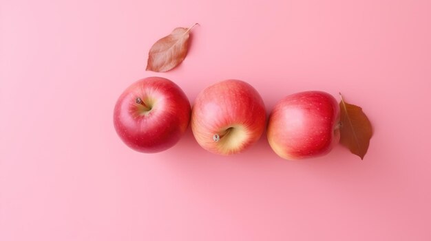 Trois pommes rouges sur fond rose