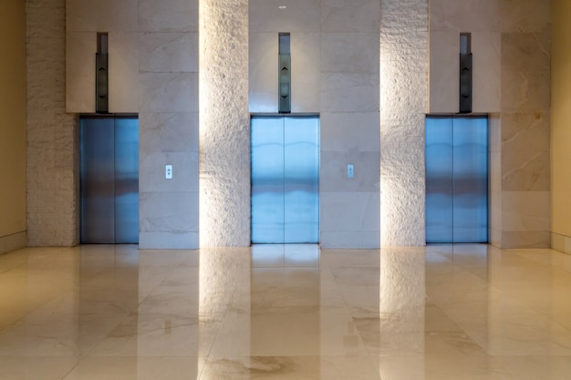 Photo trois portes d'ascenseur bâtiment intérieur avec une faible luminosité