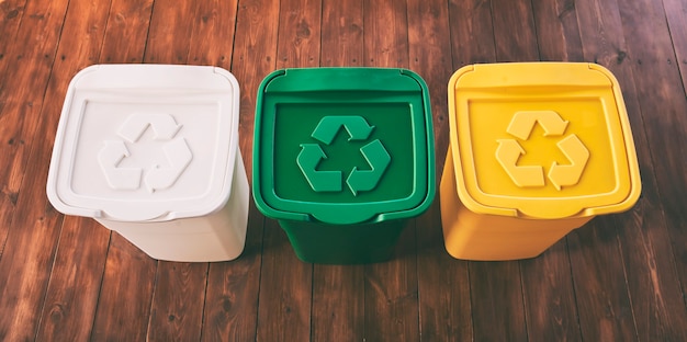 Trois poubelles colorées pour le tri des ordures. Pour le plastique, le verre et le papier