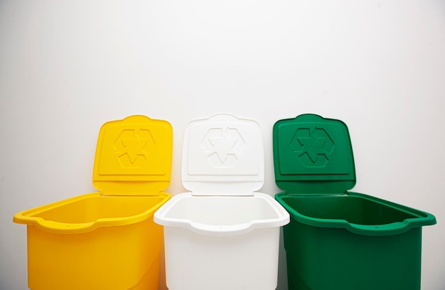 Photo trois poubelles colorées pour trier les déchets pour le verre plastique et le papier