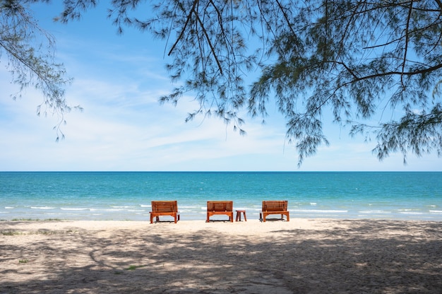 Trois salon en bois sur la plage en mer tropicale en été