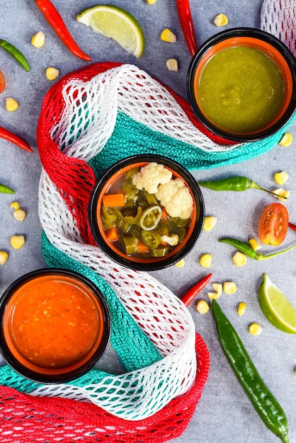 Trois sauces mexicaines aux légumes et drapeau mexicain sur fond gris