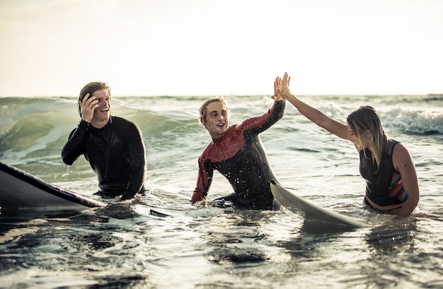 Trois surfeurs pratiquant dans l'océan