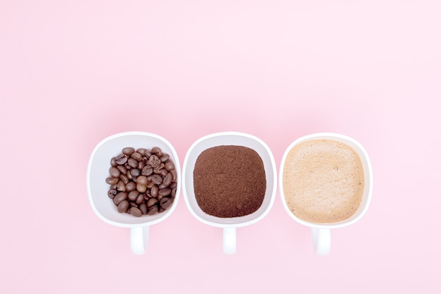 Trois tasses de différentes étapes de la préparation du café ou de la fabrication de boisson au café isolé sur rose