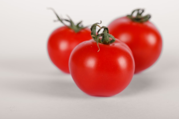 Trois tomates fraîches sur blanc