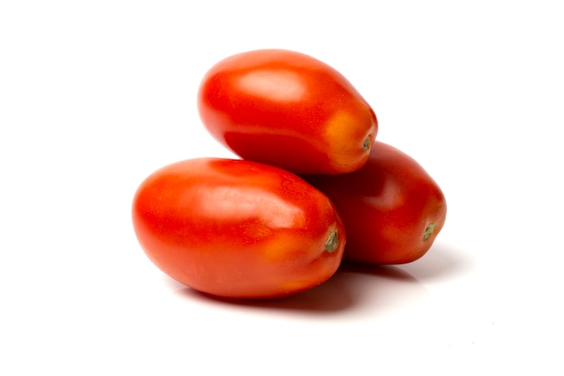 Trois tomates rouges allongées se trouvent sur un fond blanc.