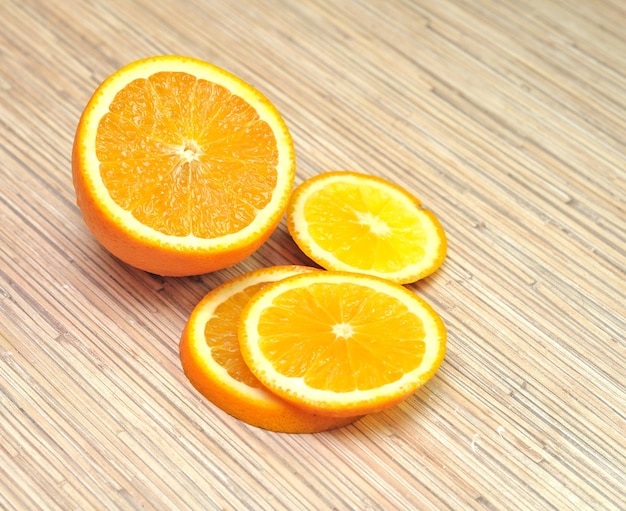 Trois tranches d'orange sont sur une table en bois avec un fond en bois.