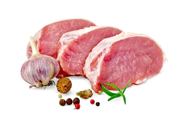 Trois tranches de viande de porc, romarin, grains de poivre, ail, muscade isolés