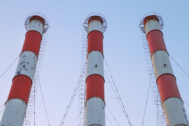 Trois tuyaux d'usine rouge et blanc fond de ciel bleu