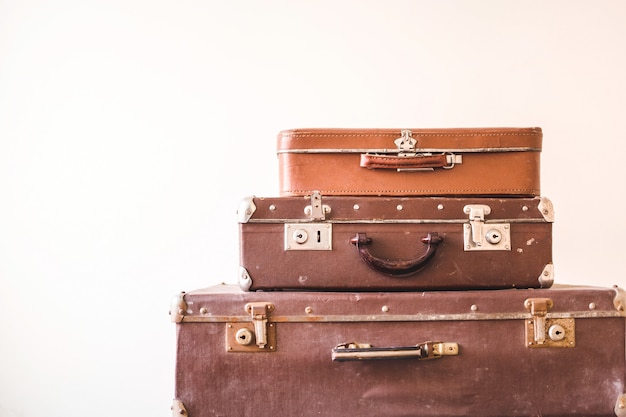 Trois vieilles valises vintage sur un fond de mur lumière. Style rétro rustique