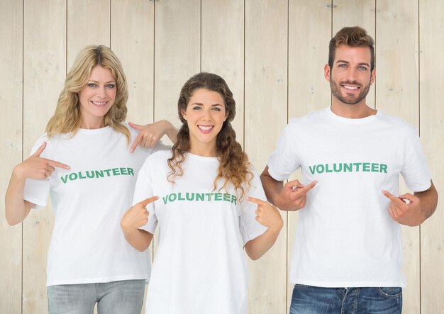 Trois volontaires pointant vers un message imprimé sur leur t-shirt