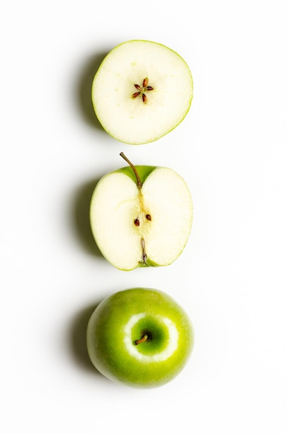 Trois vues d'une pomme verte sur fond blanc.