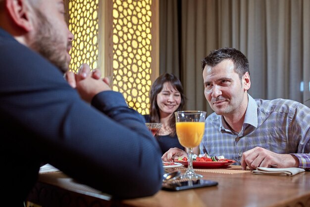 Le troisième est superflu. couple amoureux dîne dans un restaurant avec un ami solitaire.