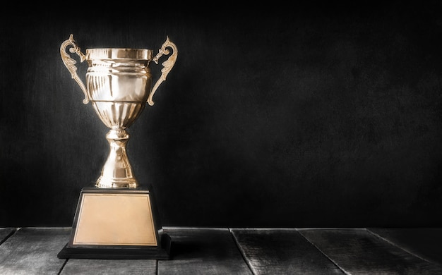 Trophée Champion d'or sur une table en bois avec espace de copie au tableau