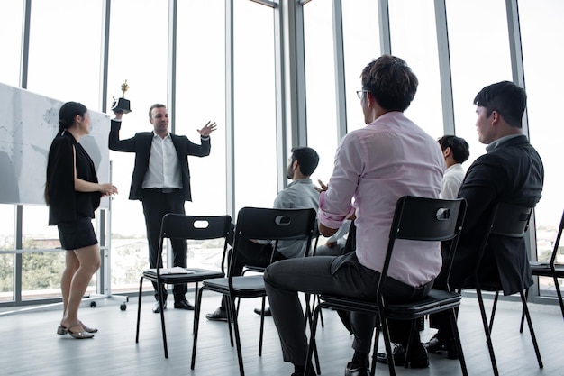 Trophée en chef aux femmes employées pour travailler avec succès. Les employées ont reçu des récompenses du chef après que sa performance ait été excellente. Concept de travail réussi pour l'entreprise.