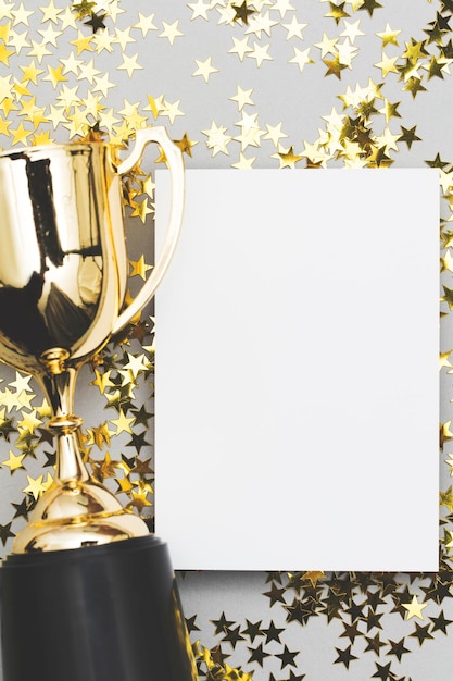 Trophée des gagnants d'or avec une étiquette d'affiche vierge et des étoiles brillantes dorées