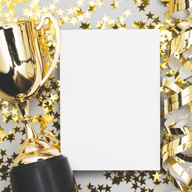 Trophée des gagnants d'or avec une étiquette d'affiche vierge et des étoiles brillantes dorées