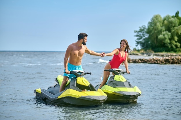 En trottinette. Un jeune couple en maillot de bain sur un scooter des mers