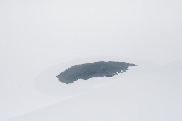 Trou de glace gelé une tache de glace sur la neige blanche Paysage minimaliste d'hiver blanc avec marigot rond avec de la glace bleue sur la rivière de neige