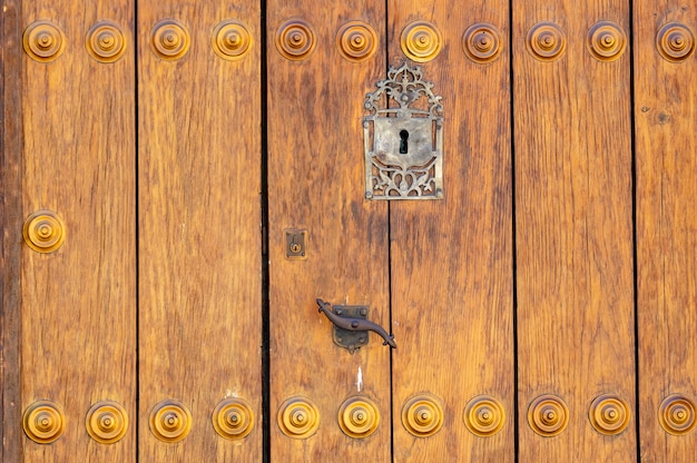 Trou de serrure dans une vieille porte en bois lambrissée; rouillé et patiné