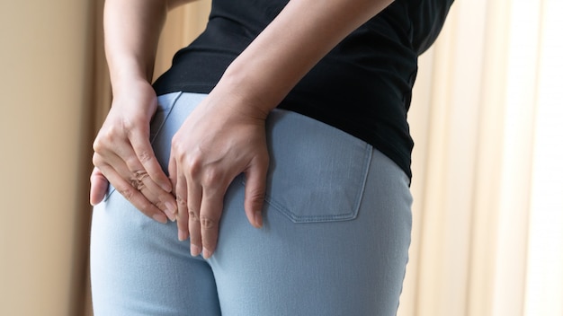 Trouble, diarrhée, incontinence. Concept de soins de santé. Main de femme tenant ses fesses