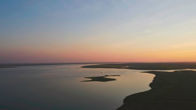 Un troupeau d'oiseaux sur le fond du coucher de soleil ciel coloré sur l'île de la rivière des oiseaux mouettes volent à