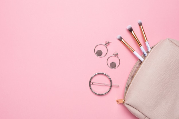 Trousse de maquillage pour femme avec pinceaux de maquillage et boucles d'oreilles avec espace de copie pour votre texte