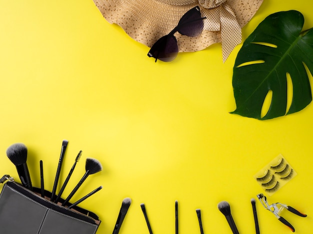 Trousse de maquillage avec une variété de produits de beauté fond jaune