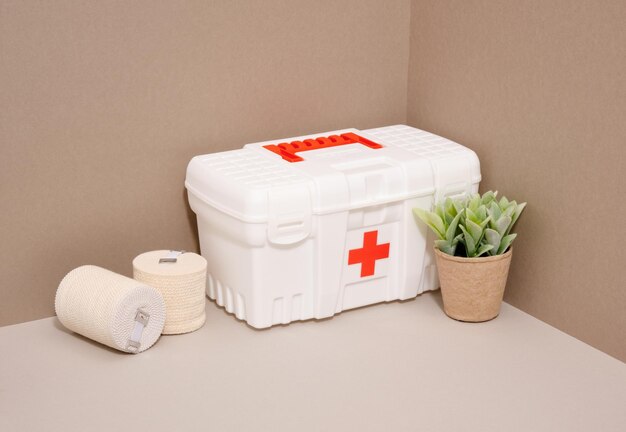 Photo une trousse de premiers soins, des bandages élastiques et une plante en pot traitement et prévention