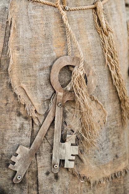 Un trousseau de vieilles clés en bois suspendu à une corde libre