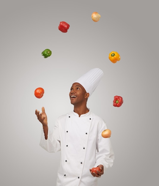 Trucs du métier Un jeune chef afro-américain jonglant avec des légumes