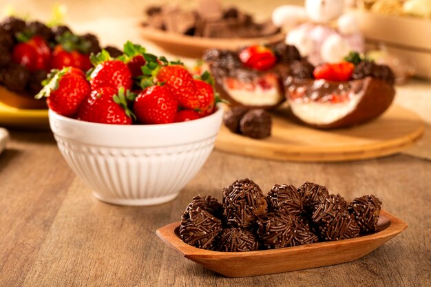 Truffe au chocolat brésilien bonbon brigadeiro sur table en bois avec fond de fraises et de Pâques.