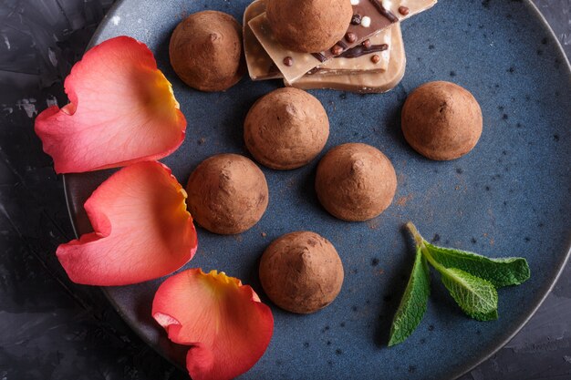 Photo truffe au chocolat avec morceau de chocolat au lait sur une plaque en céramique bleue. vue de dessus