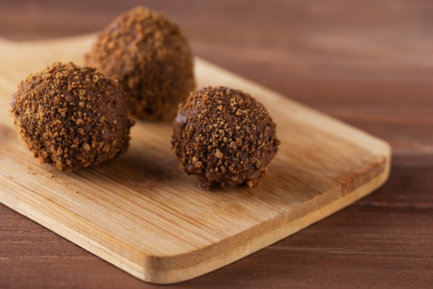 Truffes au caramel au sucre de coco sur une planche en bois.