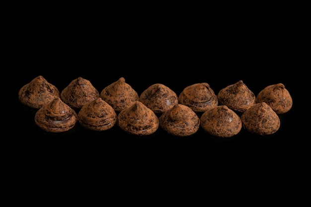 Truffes au chocolat sur fond noir. Bonbons au chocolat.