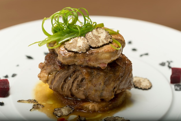 Truffes tranchées sur un steak grillé, du bœuf et du porc, avec légumes et sauce