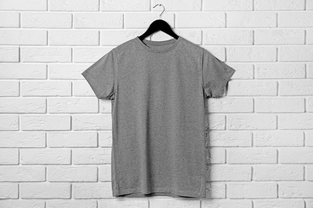 Photo tshirt gris vierge contre le mur de briques