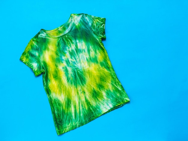 Tshirt tie dye jaune et vert sur fond bleu vif Mise à plat