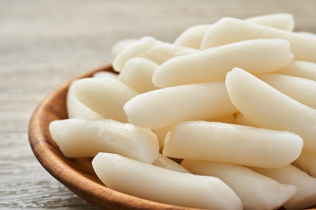 Tteok ou gâteaux de riz coréens dans une assiette en bois sur fond de table en bois