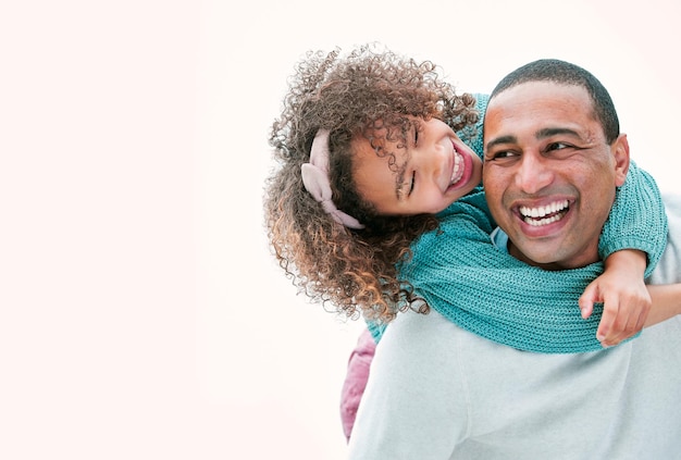 Tu es le plus grand papa du monde. Plan d'un homme portant sa fille sur son dos pendant qu'il joue dehors.