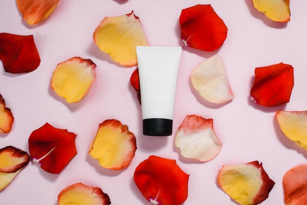 Tuba avec crème hydratante aux pétales de rose. Le concept de soin de la peau, soin anti-âge, ingrédients naturels en cosmétique